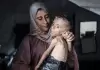 سيدة ترعى طفلها المريض في غزة.webp