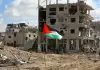 علم فلسطين يرفع أمام منزل سكني مدمر في غزة.webp