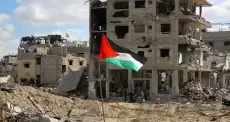 علم فلسطين يرفع أمام منزل سكني مدمر في غزة