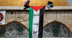 شبان يعلقون عليم فلسطين قبالة قبة الصخرة.jpg