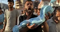 مواطن يحمل جنين قتله الاحتلال في غزة