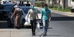 مواطنان فلسطينيان يرتديان الكمامة في قطاع غزة
