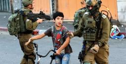 جنود الاحتلال خلال اعتقال طفل فلسطيني في الخليل رفقة دراجته الهوائية.jpg