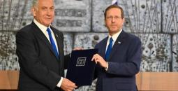 الرئيس الإسرائيلي هرتسوغ (يمين الصورة) خلال تسليم نتنياهو (يسار) كتاب تكليف الحكومة.jpg