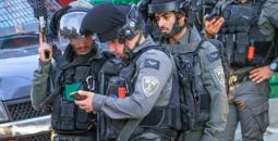 جنود من حرس الحدود يتفحصون بطاقة شاب فلسطيني.jpeg