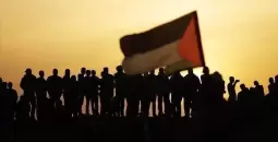 شبان فلسطينيون يرفعون علم فلسطين.webp