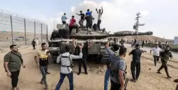 فلسطينيون يعتلون دبابة إسرائيلية على حدود غزة.webp
