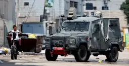 طفل فلسطيني يقطع الطريق من أمام مركبة عسكرية إسرائيلية.webp