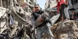 فلسطيني يحمل طفله المصاب عقب قصف إسرائيلي شمال قطاع غزة.webp