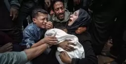 فلسطينية تحتضن طفلها للمرة الأخيرة بعد استشهاده بمجزرة إسرائيلية في غزة.webp