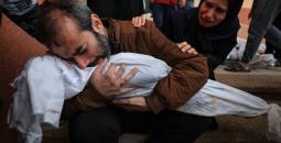 فلسطيني يودع طفلته التي استشهدت بمجزرة إسرائيلية في غزة.jpg