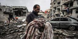 فلسطيني يحمل طفلته بعد استشهادها في مجزرة إسرائيلية بغزة.jpg