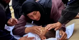 سيدة فلسطينية في غزة تودعها طفلها الشهيد.webp