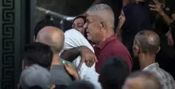 أب فلسطيني يُشيع طفله الشهيد.webp