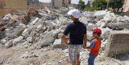 طفلان أمام منزل عائلتهما المدمر في القدس.jpg