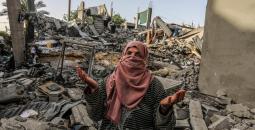 سيدة فلسطينية على أنقاض منزلها المدمر في رفح