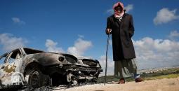 مسن فلسطيني بجانب مركبة أحرقها المستوطنون.jpg