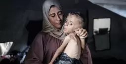 سيدة ترعى طفلها المريض في غزة.webp