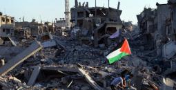 طفلان يرفعان علم فلسطين وسط الدمار في غزة.jpg