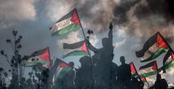 فلسطينيون يرفعون علم فلسطين في غزة مع شارة النصر.jpg