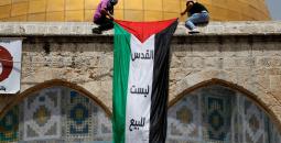 شبان يعلقون عليم فلسطين قبالة قبة الصخرة.jpg