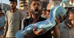 مواطن يحمل جنين قتله الاحتلال في غزة