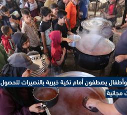 نساء وأطفال يصطفون أمام تكية خيرية بالنصيرات للحصول على وجبات مجانية