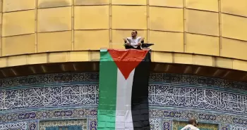 شاب فلسطيني يرفع علم فلسطين على قبة الصخرة.webp