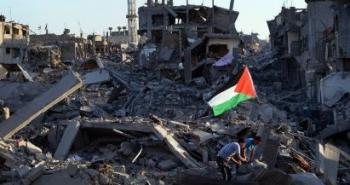 رفع علم فلسطين على أنقاض منازل مدمرة في غزة.jpg