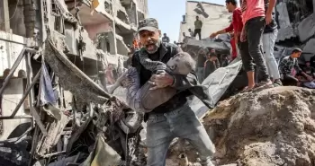 فلسطيني يحمل طفله المصاب عقب قصف إسرائيلي شمال قطاع غزة.webp