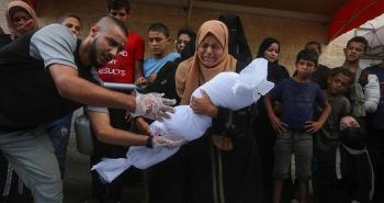فلسطينية تشيع طفلها الذي استشهد بمجزرة في غزة