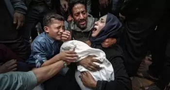 فلسطينية تحتضن طفلها للمرة الأخيرة بعد استشهاده بمجزرة إسرائيلية في غزة