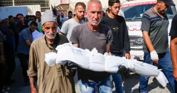 فلسطيني يحمل طفله بعد استشهاده في مجزرة بغزة.webp