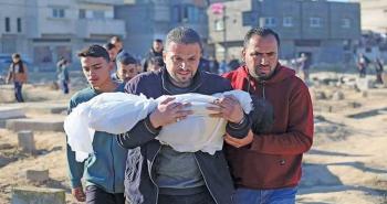 فلسطيني يحمل طفله عقب استشهاده بمجزرة إسرائيلية.jpg