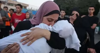 سيدة فلسطينية تودع طفلها الشهيدفي غزة