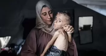 سيدة ترعى طفلها المريض في غزة.webp