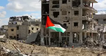 علم فلسطين يرفع أمام منزل سكني مدمر في غزة.webp