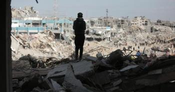 طفل فلسطيني يقف وسط أنقاض مبان مدمرة في قطاع غزة.jpg
