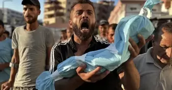 مواطن يحمل جنين قتله الاحتلال في غزة.webp