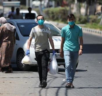 مواطنان فلسطينيان يرتديان الكمامة في قطاع غزة