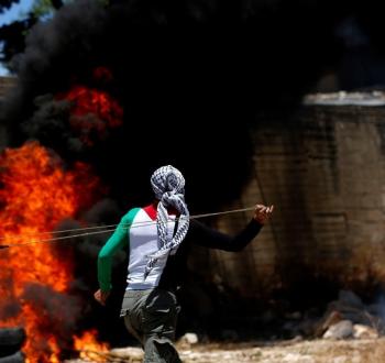 شاب فلسطيني يرشق جيش الاحتلال بالحجارة في الضفة.jpeg