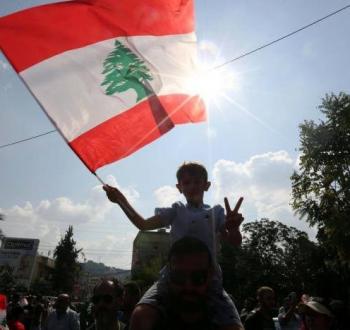 طفل لبناني يرفع علم لبنان حلال تظاهرة في بيروت.jpg