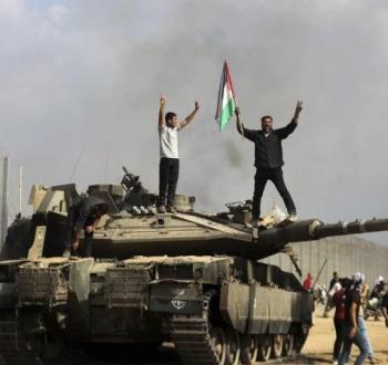فلسطينيون يعتلون دبابة إسرائيلية بعد تفجيرها.jpeg