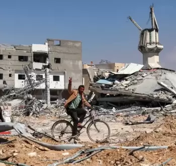 فلسطيني يرفع شارة النصر أمام مسجد دمره الاحتلال في غزة.webp