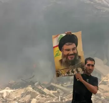 مواطن لبناني يحمل صورة للشهيد السيد حسن نصر الله.webp
