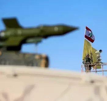 أحد عناصر حزب الله قرب مجسم لصاروخ طويل المدى