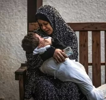 سيدة فلسطينية تحتضن طفلها الشهيد بعد مجزرة في غزة.webp