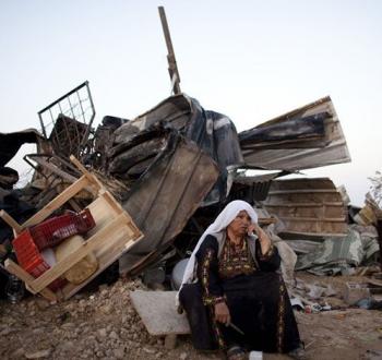 حاجة فلسطينية أمام ركام منزلها بعد هدمه من قبل الاحتلال في العراقيب.jpg