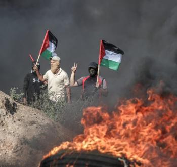 صورة لشبان فلسطينيين يرفعون علم فلسطين خلال مواجهات مع الاحتلال في الضفة الغربية.jpg