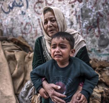 مسنة فلسطينية تحتضن حفيدها في غزة.jpg